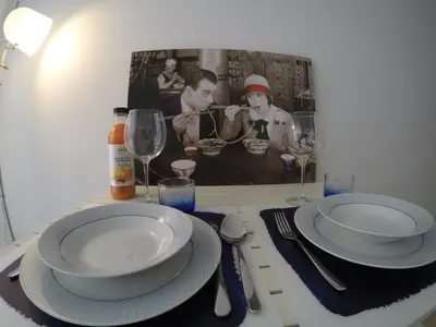 a table with plates and wine glasses and a picture at Apartamento Da Lapa in Porto