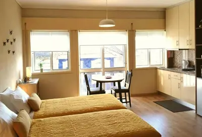 a bedroom with a large bed and a table with chairs at Cozy loft in downtown in Porto