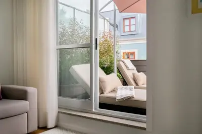 a room with a window with a couch on a balcony at Simon Guest Apartments in Porto
