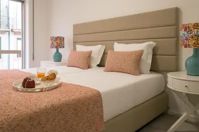 a bedroom with a bed with a tray of food on it at Simon Guest Apartments in Porto