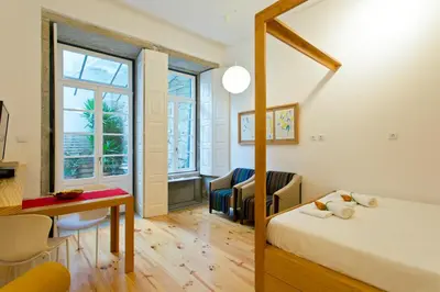 a bedroom with a bed and a desk and a table at 45 Flores: Rua das Flores/S.Bento in Porto