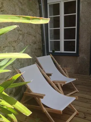 two chairs sitting on a porch in front of a window at 45 Flores: Rua das Flores/S.Bento in Porto