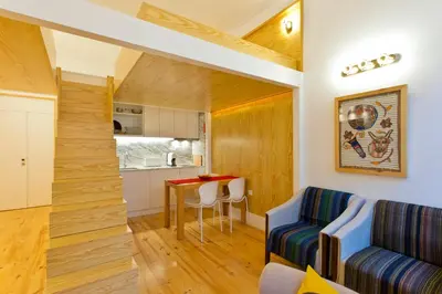 a kitchen and a living room with a table and a couch at 45 Flores: Rua das Flores/S.Bento in Porto