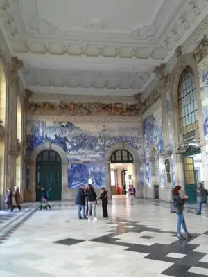 a group of people in a large room with paintings on the walls at daPraça Apartments in Porto