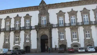 a large building with cars parked in front of it at daPraça Apartments in Porto