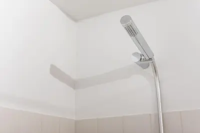 a shower head in a bathroom with a white ceiling at GuestReady - Mezzanine at the Bridge in Porto