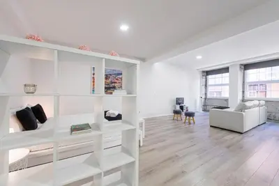 a living room with white shelves and a couch at Oporto Downtown View Apartment in Porto