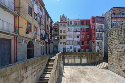 a bedroom with a white bed and a red chair at Mouzinho 244 - Porto Houses & Suites in Porto