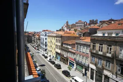 a desk with a vase of flowers and a globe on it at Mouzinho 244 - Porto Houses & Suites in Porto