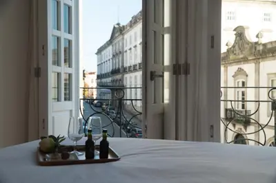 a tray of wine bottles and glasses on a table with a window at Ribeiredge Guest House in Porto