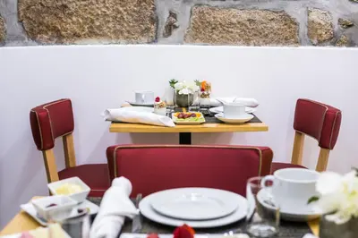 a table with two chairs and a table with plates at Ribeiredge Guest House in Porto