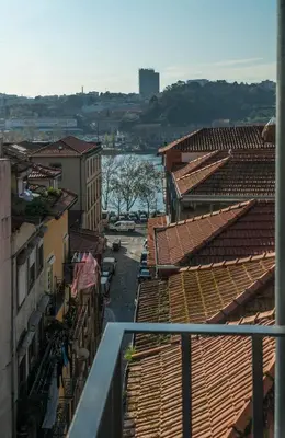 an aerial view of roofs of buildings and a river at Ribeiredge Guest House in Porto