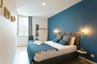 a bedroom with a large bed with blue walls at Abbey Apartments City Center Bolhão in Porto