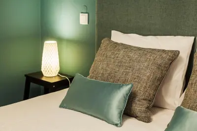 a bedroom with a bed with pillows and a lamp at Abbey Apartments City Center Bolhão in Porto