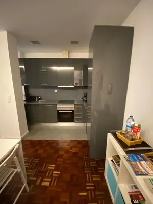 a kitchen with gray cabinets and a wooden floor at AP da Baixa in Porto