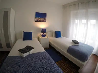 two beds in a room with blue and white at AP da Baixa in Porto