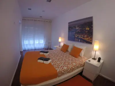a bedroom with a large bed with orange pillows at AP da Baixa in Porto