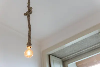 a light bulb hanging from a ceiling next to a window at GuestReady - Urban oasis with private balcony in Porto