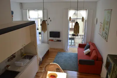 a living room with a red couch and a television at Oporto Old In New in Porto