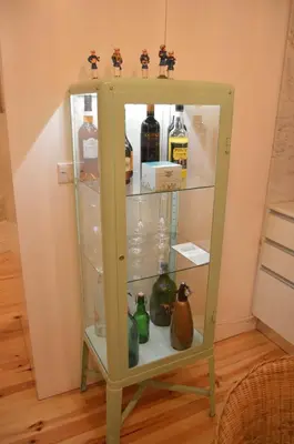 a green cabinet with bottles of alcohol in it at Oporto Old In New in Porto