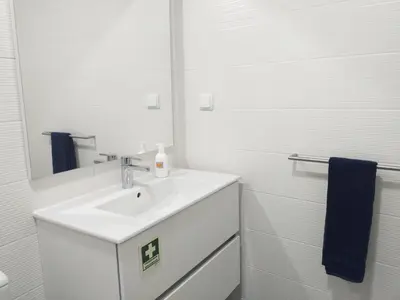 a white bathroom with a sink and a mirror at H2O Porto Ribeira in Porto
