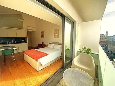 a bedroom with a bed and a balcony with a kitchen at PORTO SWEETHEART - Almada in Porto
