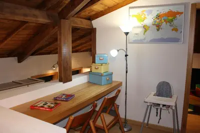 a room with a desk with a lamp and a table with chairs at Casa São Dinis in Porto
