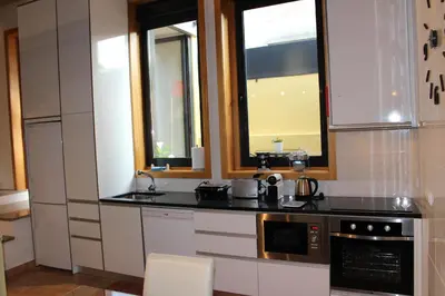 a kitchen with a counter and two windows at Casa São Dinis in Porto