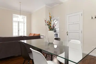 a dining room with a glass table and white chairs at Chateau Belomonte in Porto