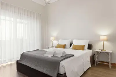 a white bedroom with a large bed with two pillows at Chateau Belomonte in Porto