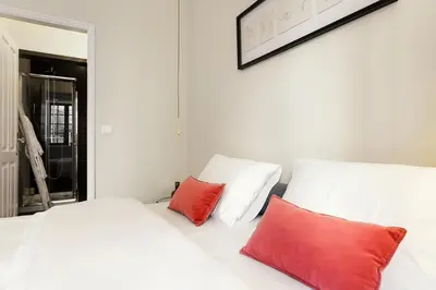 a white bed with two red pillows in a room at Chateau Belomonte in Porto