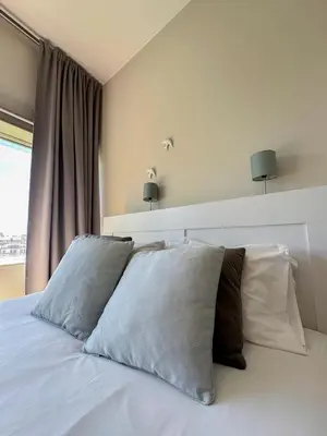 a bedroom with a white bed with two pillows at Oporto Trindade Residence in Porto