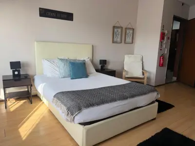 a bedroom with a large white bed with blue pillows at Oporto Trindade Residence in Porto