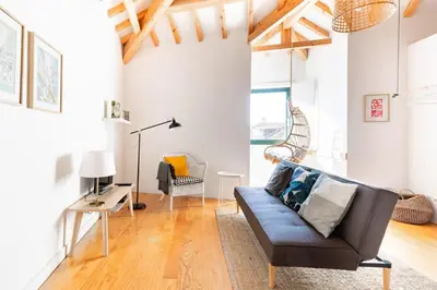 a living room with a couch and a chair at Loft 72 in Porto