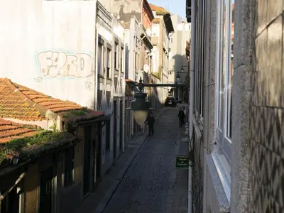 an alley with buildings and a person walking down the street at Merc Porto Central Place in Porto