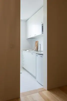 a kitchen with white cabinets and a counter top at Casa da Figueiroa in Porto