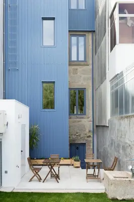 a blue building with two benches and a table at Casa da Figueiroa in Porto