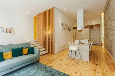 a living room with a blue couch and a table at Old Stone Flats by Host Wise in Porto