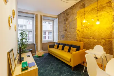 a living room with a yellow couch and a table at Old Stone Flats by Host Wise in Porto