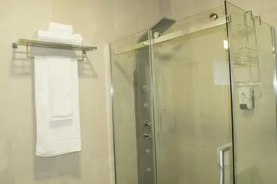 a shower with a glass door and white towels at Merc Porto Ribeira`s Place in Porto