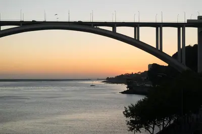 a bridge over a river with a boat in the water at Merc Porto Ribeira`s Place in Porto