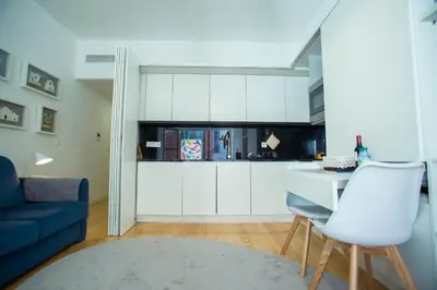 a kitchen with white cabinets and a blue couch at Almada Story Apartments by Porto City Hosts in Porto