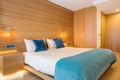 a bedroom with a large bed with blue pillows at Almada Domus in Porto