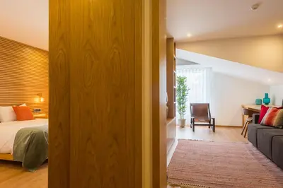 a bedroom with a bed and a living room at Almada Domus in Porto