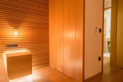a bedroom with a wooden accent wall and a bed at Almada Domus in Porto