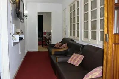 a living room with a black leather couch with pillows at Mira Porto House in Vila Nova de Gaia