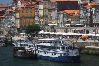 two boats are docked in the water in a city at Cozy Flat Porto Downtown in Porto