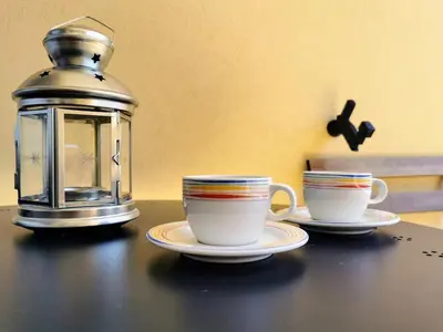 two cups of coffee sitting on a table with a lantern at Vale Formoso Apartment in Porto