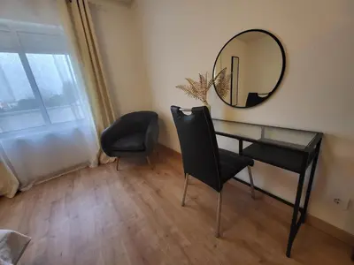 a desk with a mirror and two chairs in a room at Vale Formoso Apartment in Porto