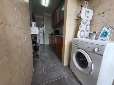 a washer and dryer in a small kitchen at Vale Formoso Apartment in Porto